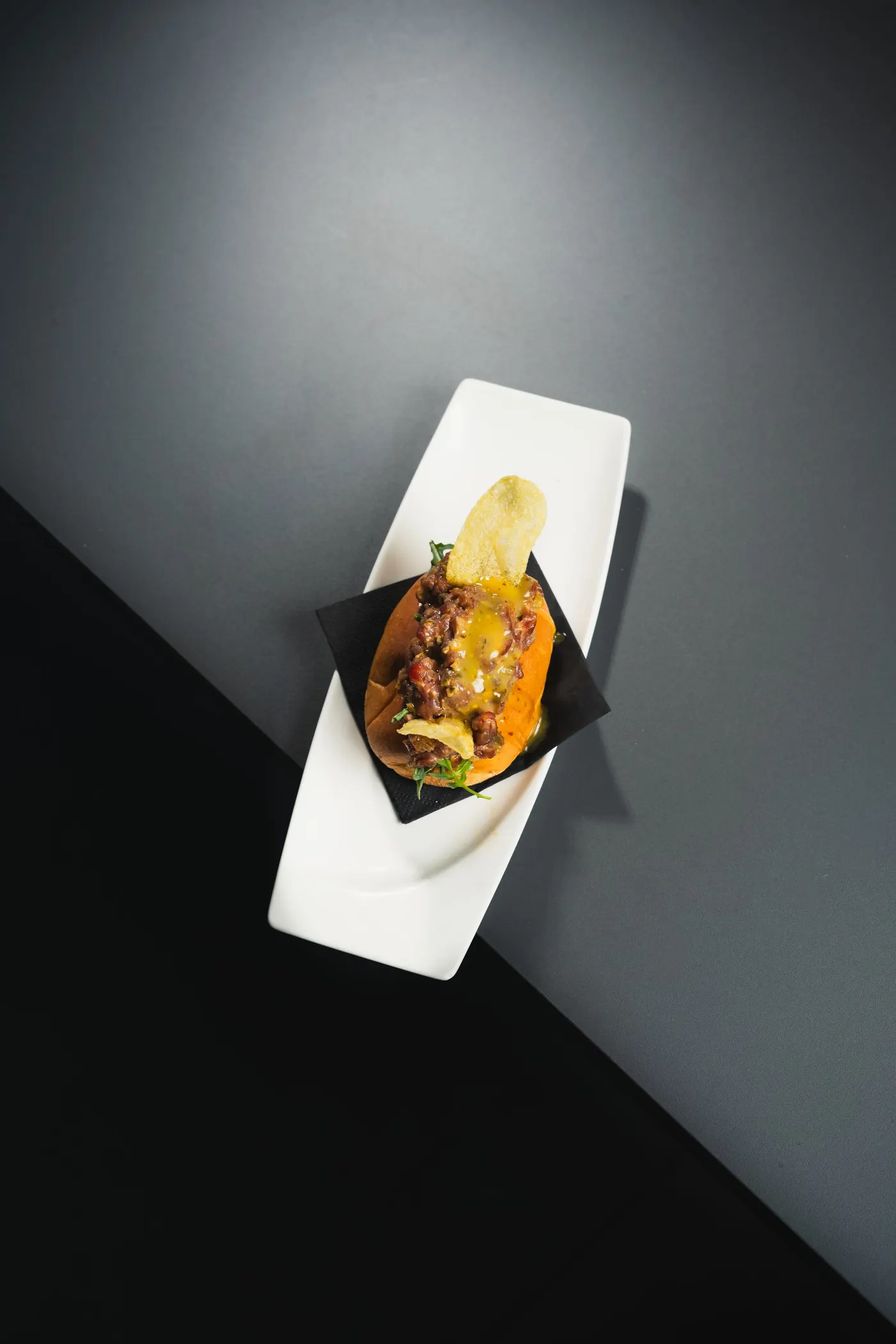 Brioix acabat de forn farcit de steak tartar amb emulsió de mostasses